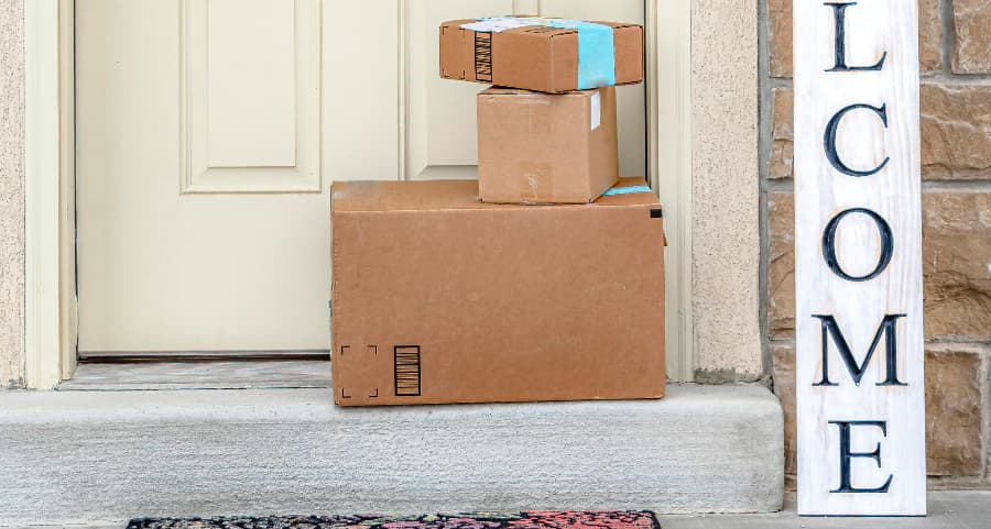 Packages on the doorstep of a home with a welcome sign in Asheville